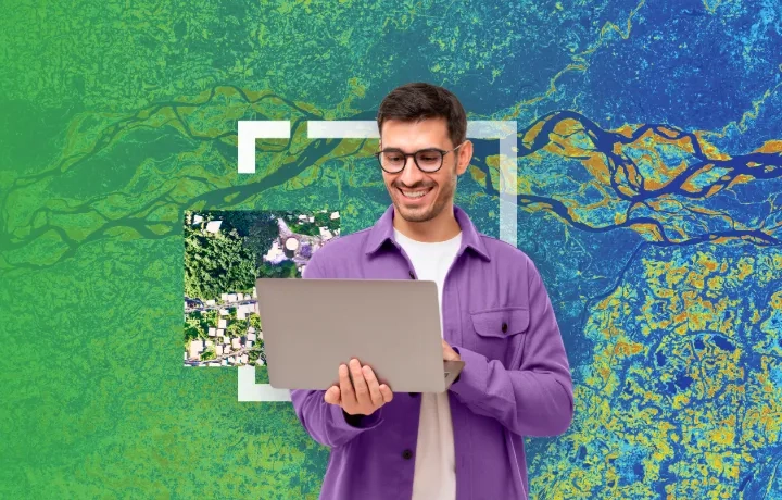 Person on laptop in front of map imagery
