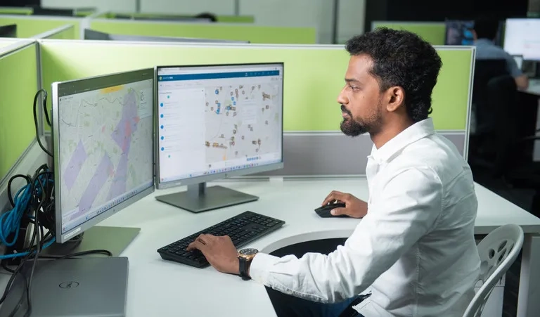 GIS analyst reviewing maps, imagery, and spatial data across dual monitors