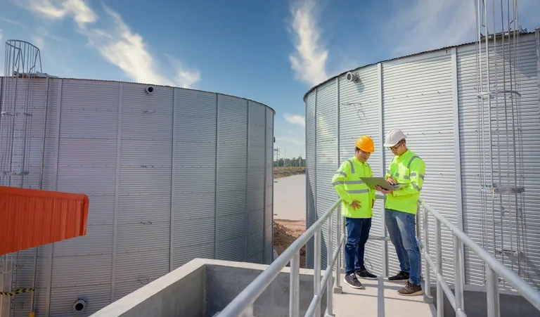 Workers using GIS-enabled field technology at an industrial facility to access spatial data, imagery, and asset information in real time.